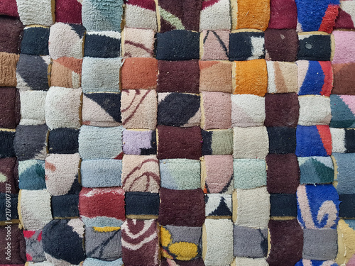 Obraz na plátně Colorful patchwork doormat made from assorted textured fabric pieces arranged in a geometric pattern, close up household floor mat background