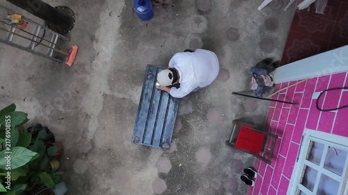 High Angle Aerial View of Worker Opening Paint Can and Coating Metal Sheet