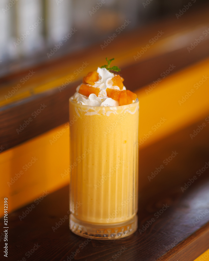 Obraz premium Mango Smoothie with Whipped Cream and Fruit Topping Close-Up