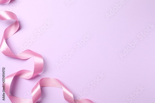 Pink satin ribbon on purple background 