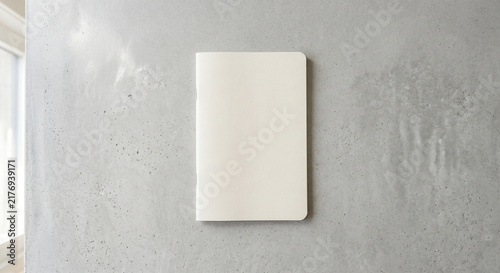Blank white paper notebook mockup on gray concrete wall background vertical flatlay top view for stationery design and corporate branding presentation