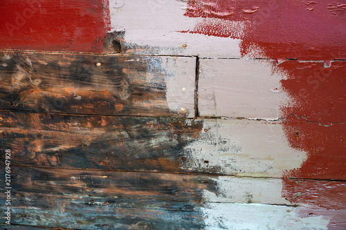 Close-up of wooden boat hull repair and maintenance, showing stripping, repainting, and sealing processes on old planks.