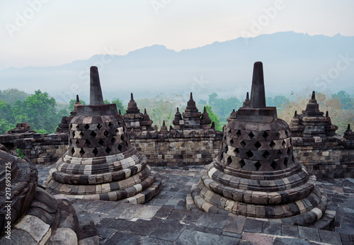 Fotografie The stupas of Borobudur Temple in the early morning mist (Indonesia)