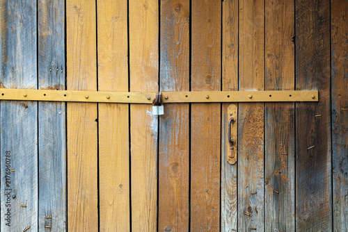 Fotografie Weathered wooden door secured with a simple metal latch