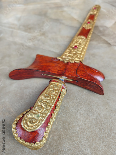 Bild auf Leinwand Traditional Indonesian Kris Dagger Hilt with Golden Carving and Sheath Close Up