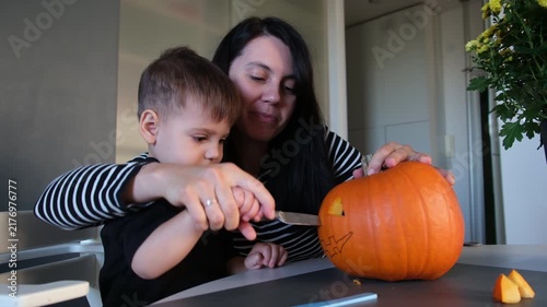 Mother and son opening carved pumpkin