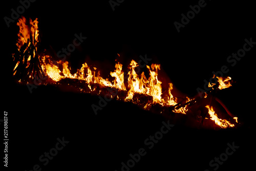 Konstfotografi A horizontal trail of bright orange flames and burning wood logs glowing intense