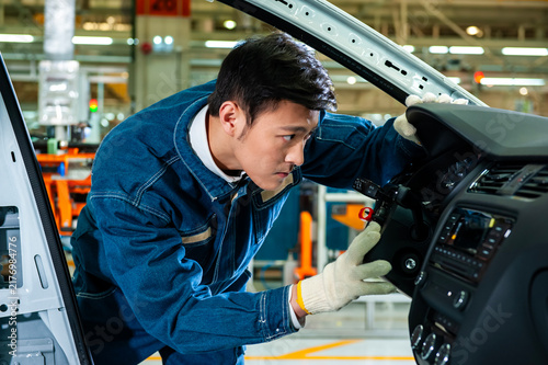Konstfotografi Asian industrial workers are focused on installing interior parts for car dashboards