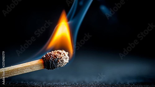 Closeup burning match with blue flame, tiny smoke curling upward, charred head and wooden stem resting on textured surface, dramatic lowkey lighting and shallow