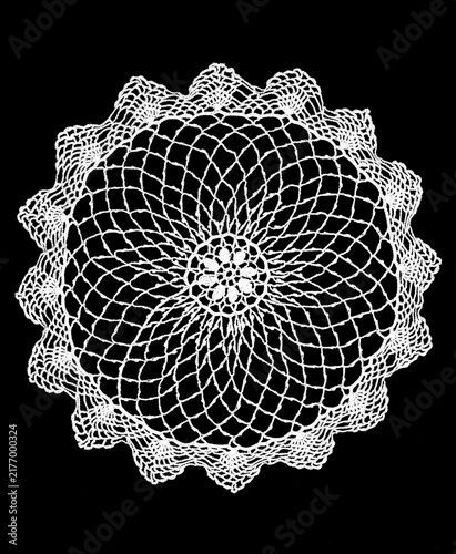 Round crochet lace doily isolated on black background, crocheted Grandma's Doily, detail of hand-crocheted embroidery, tablecloth, napkin art design. Craft, vintage linen. Flat lay. Top view