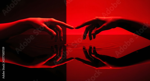 Two hands reach toward each other over a reflective red liquid surface, fingers nearly touching with concentric ripples spreading. Podcast cover for themes of emotional connection