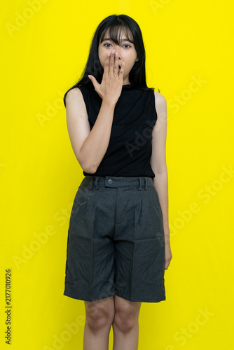 Canvastavla Shocked Young Woman In Casual Clothing Covering Her Mouth Against Vibrant Yellow