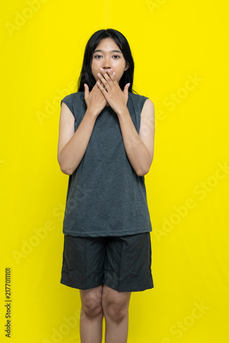 фотографія Shocked Young Woman With Hands Covering Her Mouth Wearing Grey Casual Clothes On
