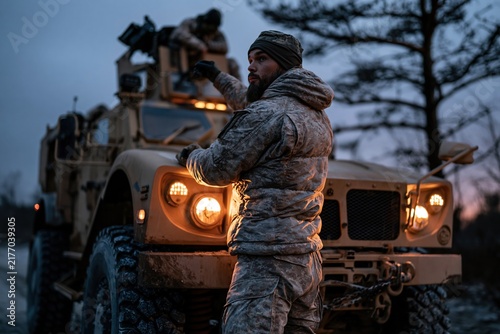 Soldier Beside Armored Vehicle at Dusk