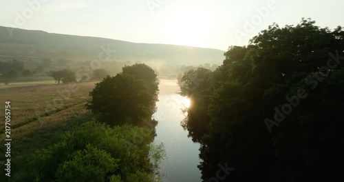 Sunrise over misty river and valley