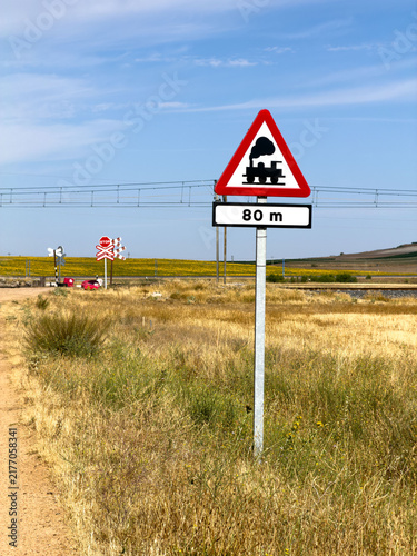 Rural Railroad Crossing Sign With Train Icon and 80m Distance Marker in Summer Countryside