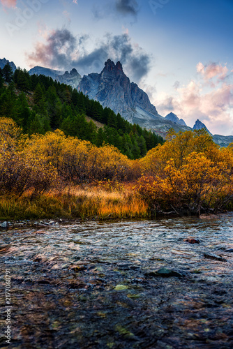Rocky Mountain Peak over River Flowing Surrounded by Larch Forest in Claree Valley French Alps Nevache France