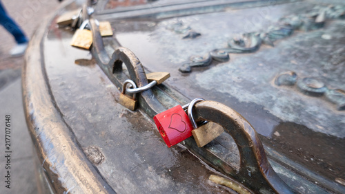Fotografía Lovers placing heart lock on metal structure for eternal commitment
