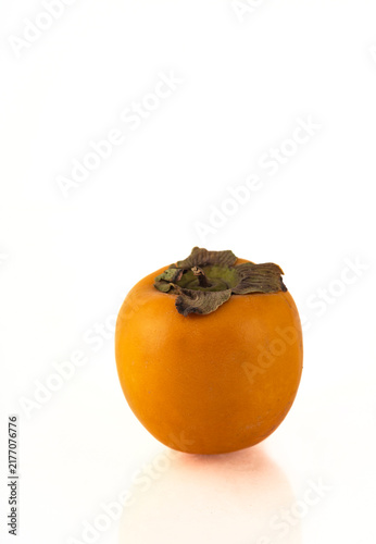 Ripe persimmon fruit on a white background with reflection.