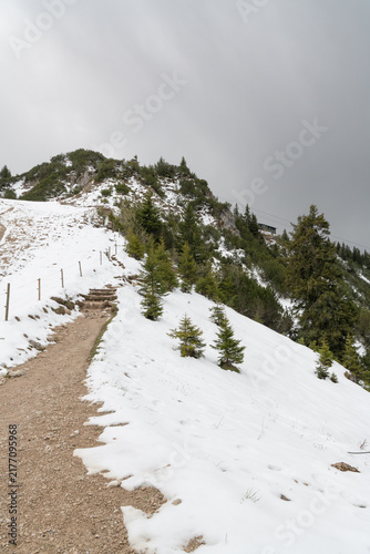 Footpath from the top of Tegelberg Mountain through snow and  the Alpine landscape,  Swabia , Bavaria, Germany