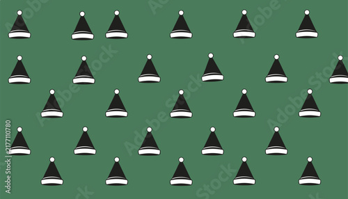 Pattern of black Santa hats with white trim against a solid green background for festive Christmas holiday greeting card design usage.