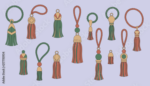 Multiple decorative hanging tassels with rope loops in green red and gold colors arranged for fashion and interior design accessories.