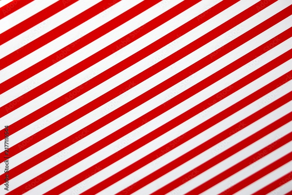 Obraz premium Représentation de bandes rouges et blanches parallèles et disposées en diagonal. Motifs répétitifs de lignes espacées régulièrement.