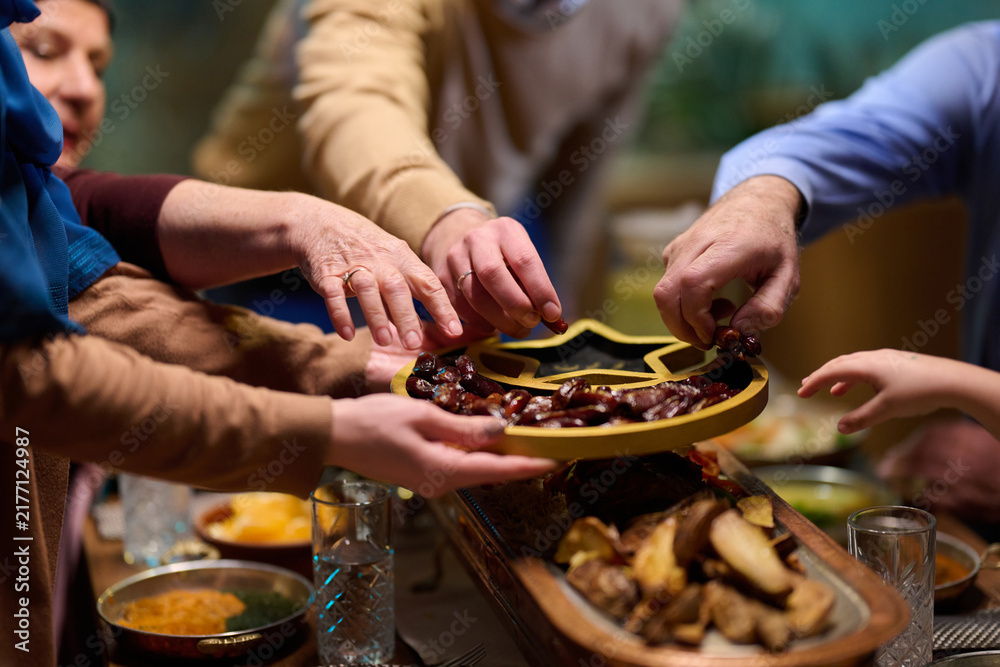 Naklejka premium Family Sharing Dates From A Star-Shaped Tray During Festive Iftar Gathering At Home
