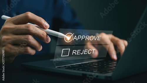 Person using a stylus to select the approve option on a digital laptop interface with over laptop computer uses stylus check approve box technology
