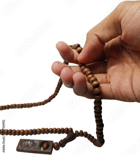 фотографія hand holding brown wooden prayer beads or tasbih