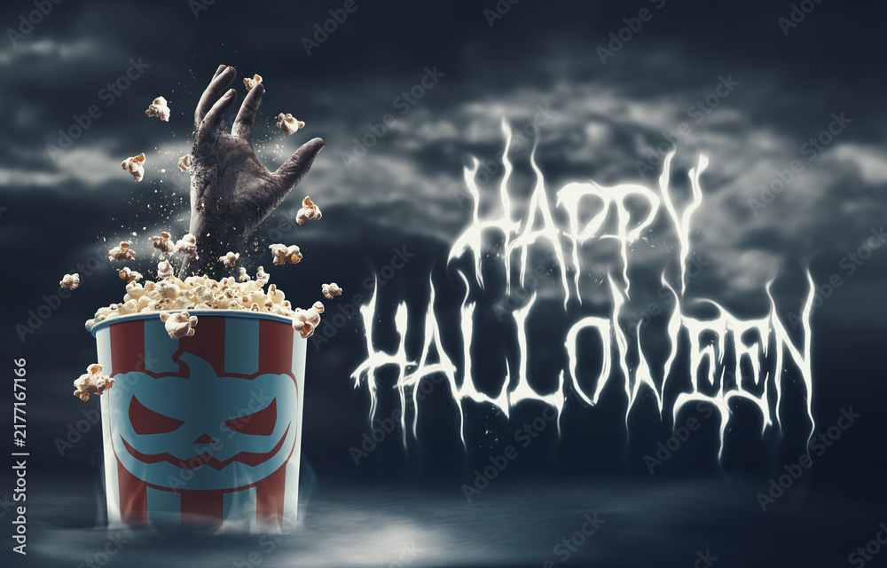 Obraz premium Happy Halloween wishes and zombie hand in a popcorn bucket