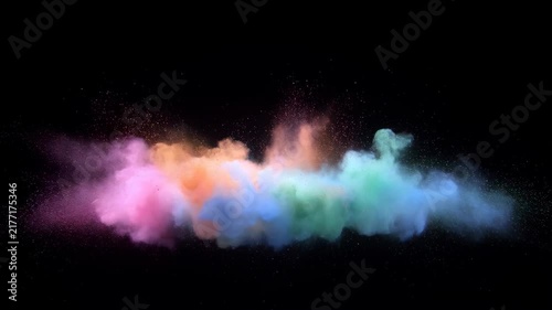 Multicolored powder cloud bursts and expands across a black background in a vivid abstract display