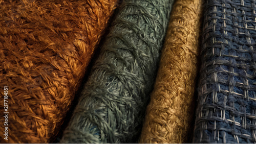Stack of colorful woven textile rolls with ethnic geometric designs