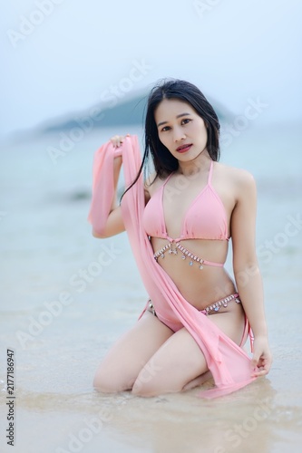 Woman in Pink Swimsuit Posing at Beach During Summer Day