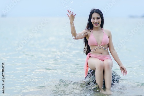Happy Woman in Pink Swimsuit Playing at Beach in Summer Setting