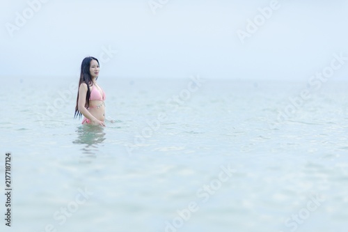 Woman in Pink Swimsuit Standing in Shallow Water at the Beach