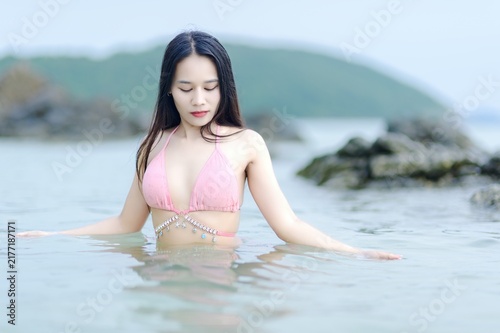 Woman in Pink Swimsuit Enjoying a Serene Beach Day in Summer