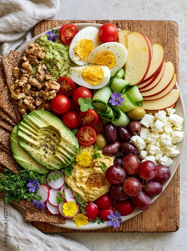 The image is of a platter of food arranged on a wooden cutting board.