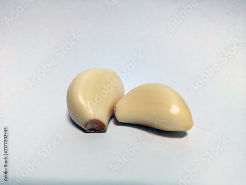 Foto High angle view of two fresh, clean, and organic peeled garlic cloves on a plain white backdrop