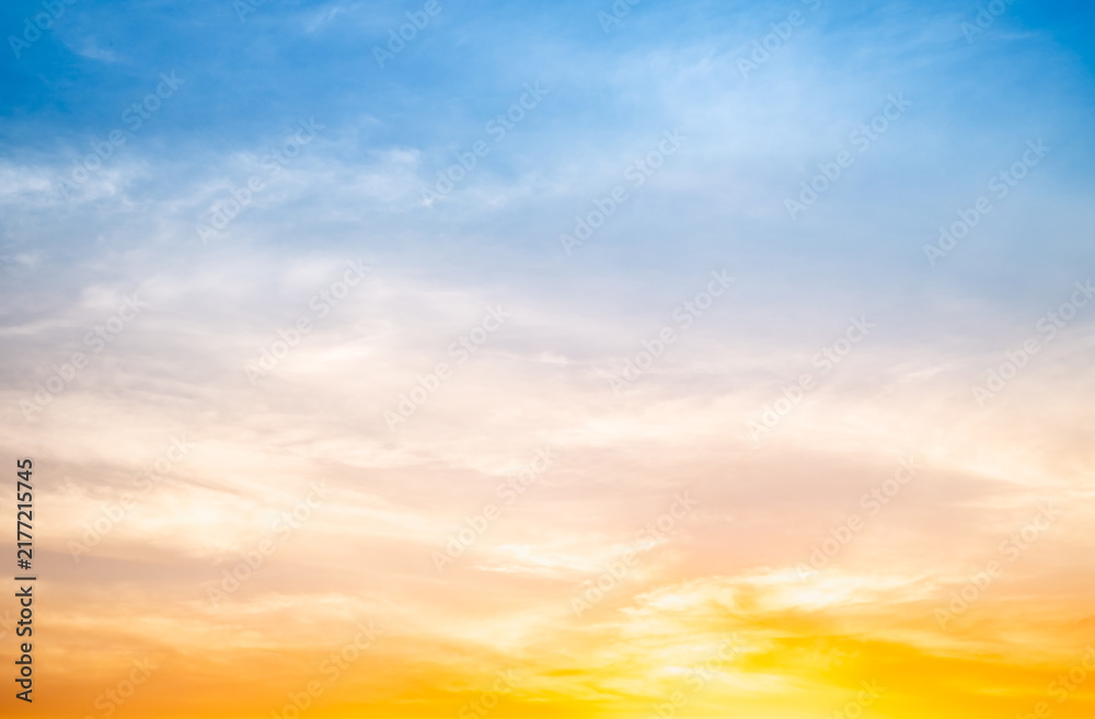 Fototapeta premium Sunset or sunrise sky with a vibrant gradient of orange, gold, and soft blue. Clear atmosphere with wispy clouds. Peaceful, natural light background. hope, freedom, new day and inspirational Concepts