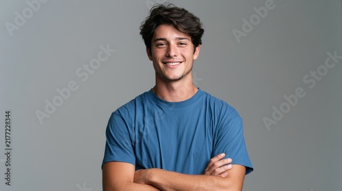 Professional head-and-shoulders portrait of a European man in a blue tee smiling at the camera