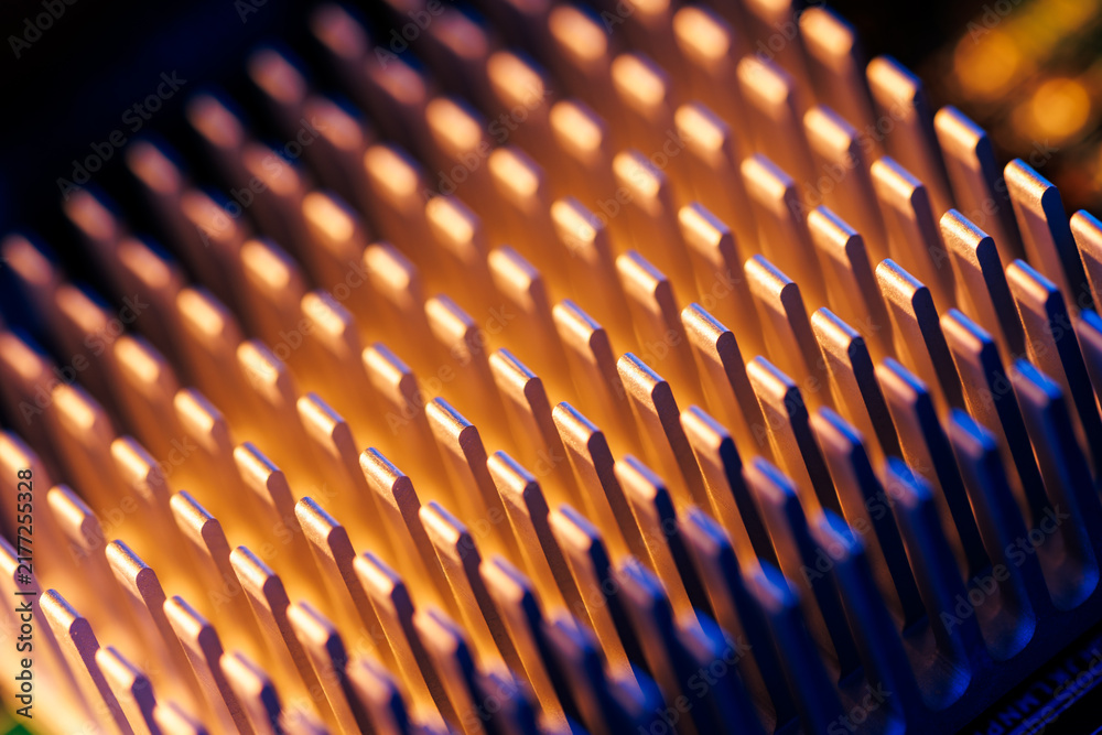 Obraz premium Closeup metallic heatsink fins macro background with blue and orange neon lighting for technology