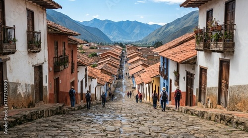 Charming colonial town street with cobblestone path and mountain background