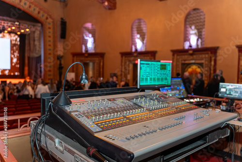 Obraz na plátne Professional audio mixing console inside a vintage theater, featuring sliders, buttons and digital displays