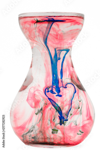Canvas Print Colorful streaks of dye dissolved and submerged in a glass jug of water, artisti