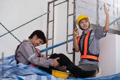 фотографія Construction workers responding to a workplace injury, with an injured colleague in pain while a supervisor signals for help, highlighting emergency response, safety, teamwork, first aid, prevention
