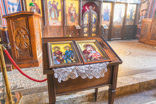 Obraz na plátně Framed religious icons displayed on a wooden stand in an Orthodox church interior