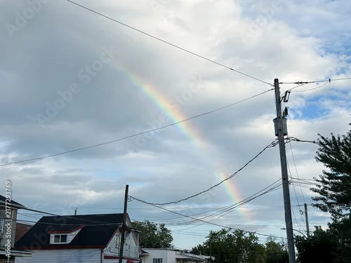 Fototapeta na wymiar Un poteau électrique en ville et un arc-en-ciel, Québec, Canada.
