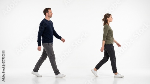 Side view of a man and a woman walking together isolated on white background