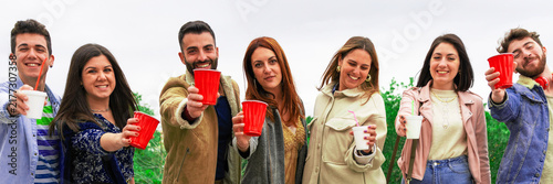 Foto Group of happy friends enjoying drinks outdoors, smiling and celebrating together